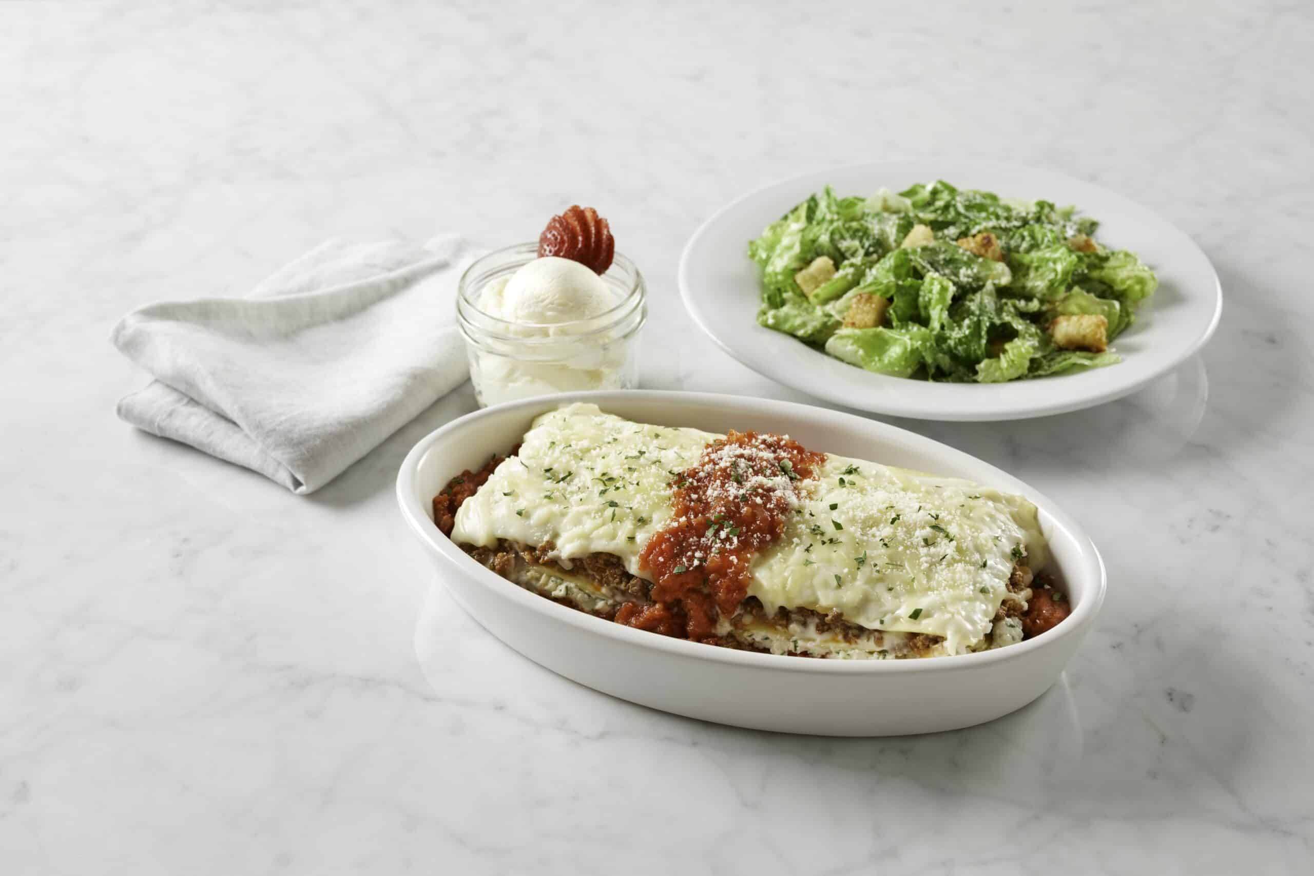 Brio lasagna with caesar salad on a table